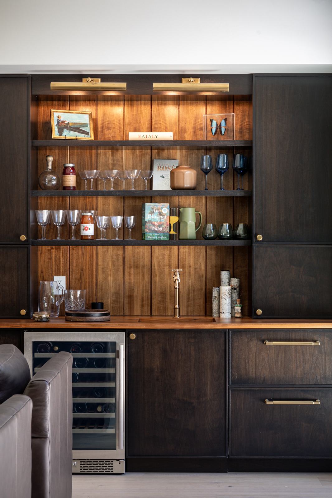 Walnut built-in bar cabinetry with lit shelving